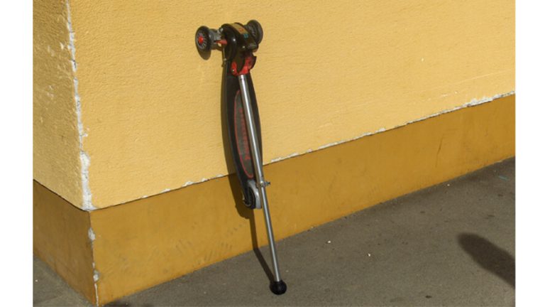Zložen skiro Streetboard prislonjen na zid.