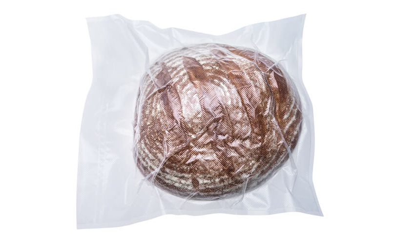 Zavakuumiran hlebec kruha v XL vrečki na belem ozadju.